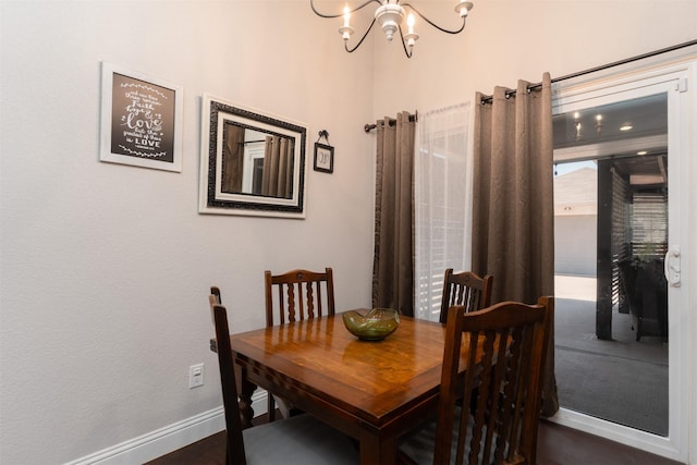 dining space with baseboards and a notable chandelier