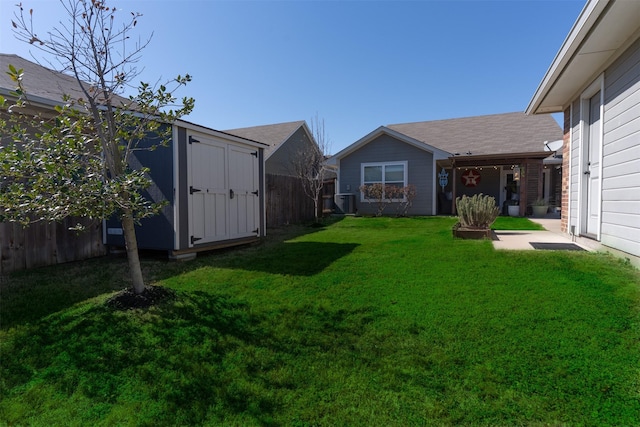 view of yard with central AC, a storage unit, fence, and an outdoor structure