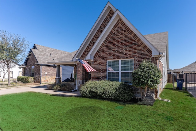 view of front of house featuring brick siding, fence, roof with shingles, a front lawn, and concrete driveway
