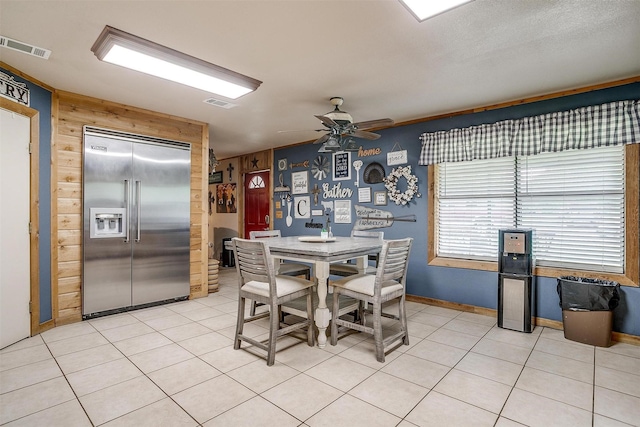 7203 Pump Station Rd, Jacksboro, TX 76458 - dining room featuring light tile patterned floors, ceiling fan, and wooden walls
