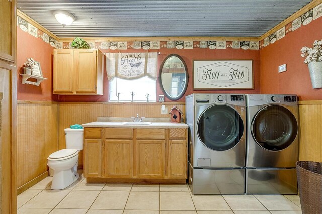 7203 Pump Station Rd, Jacksboro, TX 76458 - laundry room with washer and dryer, a sink, light tile patterned floors, a wainscoted wall, and crown molding