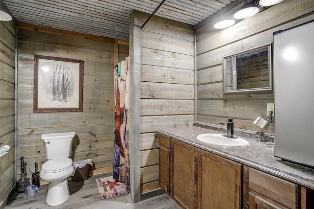 7203 Pump Station Rd, Jacksboro, TX 76458 - bathroom featuring wood walls, toilet, wood finished floors, vanity, and a shower with curtain