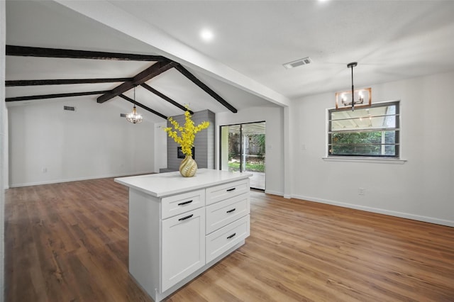 kitchen featuring white cabinets, baseboards, open floor plan, and a notable chandelier