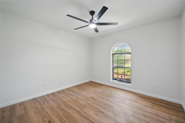 spare room with light wood-type flooring, baseboards, and ceiling fan
