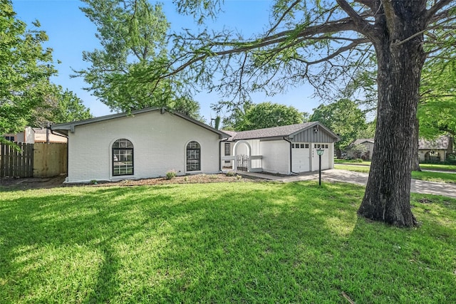 view of front of home featuring brick siding, fence, a front yard, concrete driveway, and an attached garage