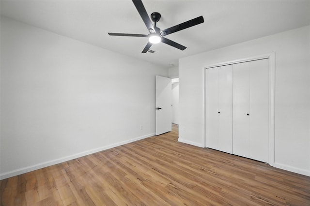 unfurnished bedroom with ceiling fan, visible vents, a closet, baseboards, and light wood-type flooring