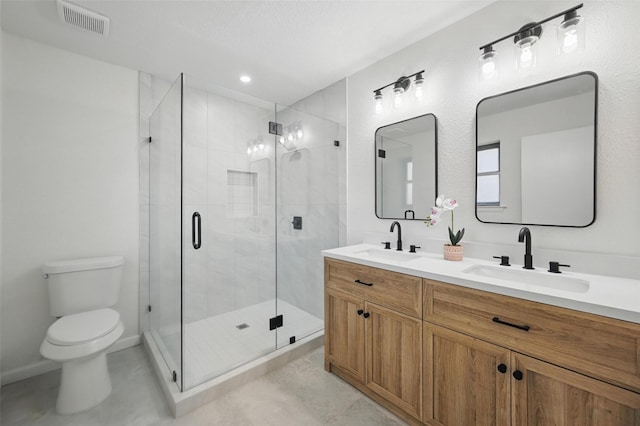 full bathroom with a stall shower, a sink, double vanity, and toilet