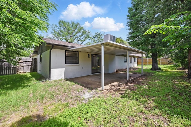 back of house with a chimney, fence, a patio, a lawn, and brick siding