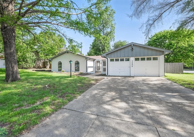 single story home featuring a front yard, a garage, driveway, board and batten siding, and fence