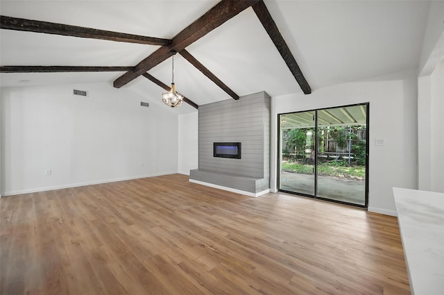 unfurnished living room featuring lofted ceiling with beams, baseboards, a notable chandelier, and light wood-style flooring