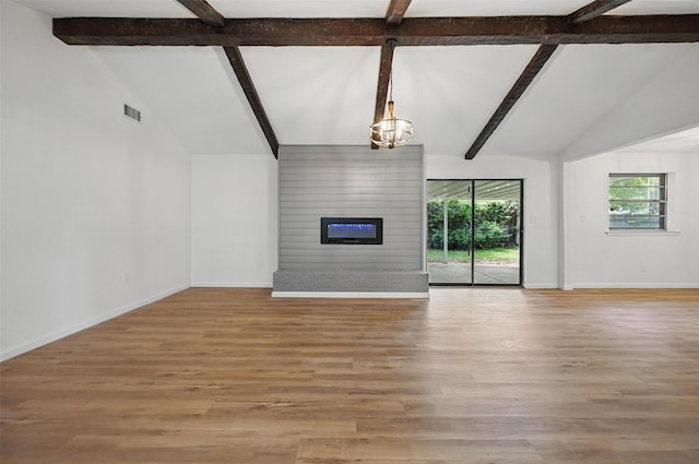 unfurnished living room featuring an inviting chandelier, wood finished floors, visible vents, baseboards, and lofted ceiling with beams