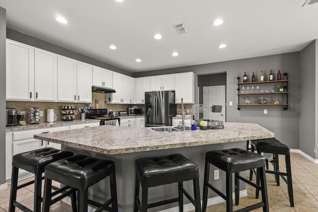 6521 Fitzgerald St, Fort Worth, TX 76179 - kitchen featuring stainless steel appliances, a kitchen breakfast bar, visible vents, and light tile patterned floors