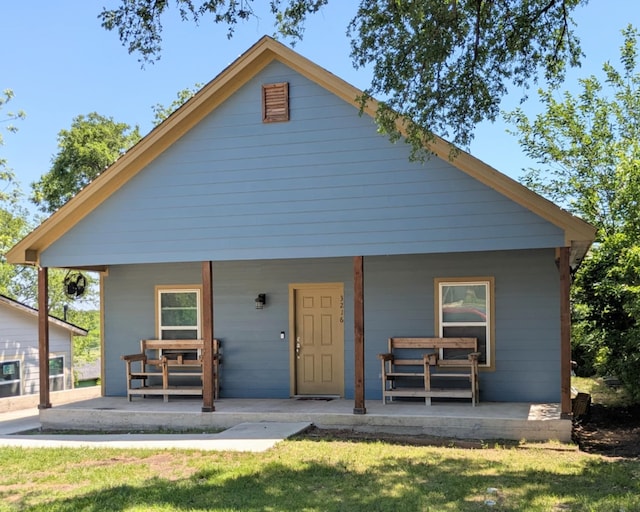bungalow featuring a front yard and covered porch