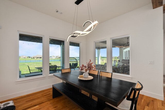 dining area with visible vents, light wood finished floors, and baseboards