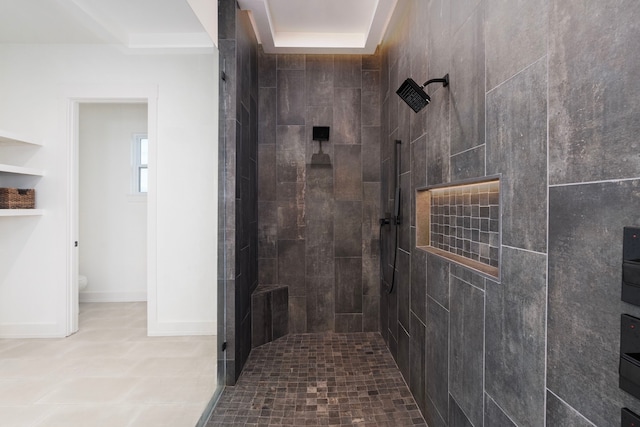 full bathroom with a tile shower and toilet
