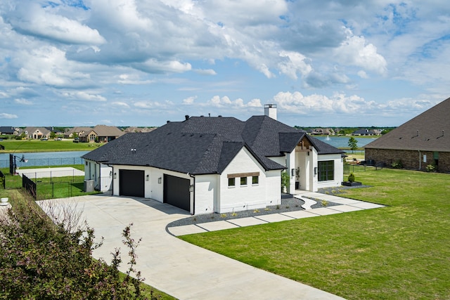 view of front of house featuring a garage, driveway, a chimney, and fence