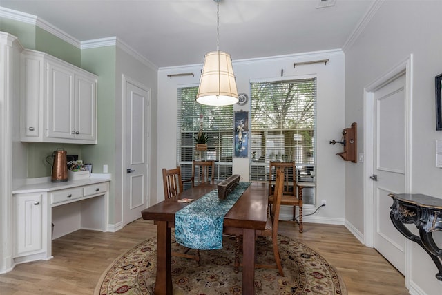 dining area featuring baseboards, ornamental molding, and light wood-style flooring