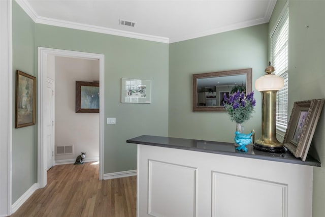 hall with visible vents, baseboards, crown molding, and wood finished floors