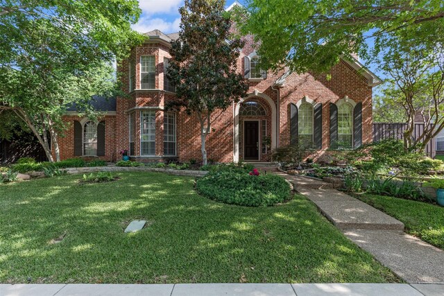 view of front of property with a front yard and brick siding