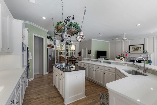 kitchen with crown molding, ceiling fan, a sink, stainless steel fridge with ice dispenser, and recessed lighting