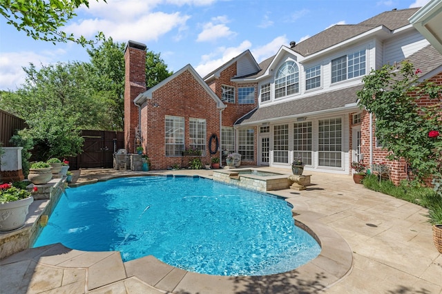 view of swimming pool featuring a pool with connected hot tub, fence, a gate, and a patio area