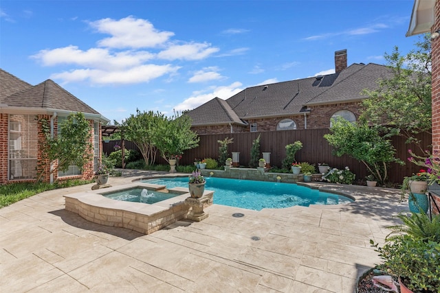 view of pool featuring a patio, a pool with connected hot tub, and a fenced backyard