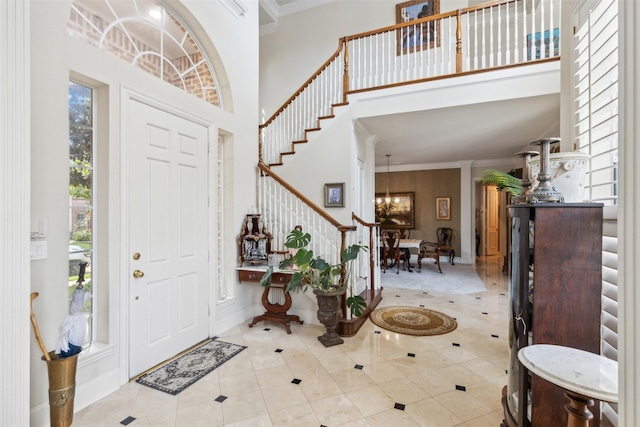 entrance foyer with stairs, tile patterned floors, an inviting chandelier, and a towering ceiling