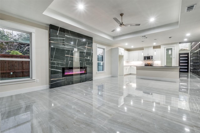 1963 Dennison St, Dallas, TX 75212 - unfurnished living room with a tray ceiling, baseboards, a ceiling fan, recessed lighting, and a high end fireplace