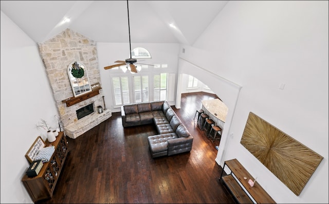 living room featuring wood finished floors, a stone fireplace, high vaulted ceiling, and a ceiling fan