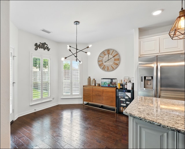 dining room featuring dark wood finished floors, wine cooler, visible vents, baseboards, and a chandelier