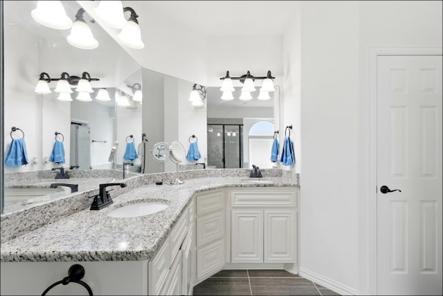 full bathroom with a sink, double vanity, and a stall shower