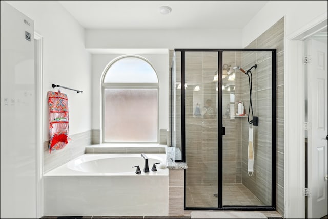 full bath featuring a bath and a shower stall