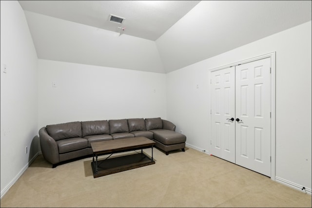 living room featuring baseboards, vaulted ceiling, visible vents, and light carpet
