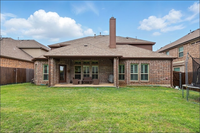 rear view of property with a patio area, a fenced backyard, a chimney, and a trampoline
