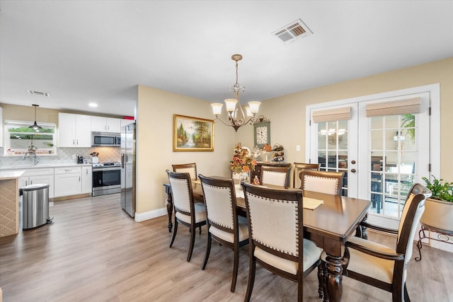 1410 Hummingbird Dr, Hillsboro, TX 76645 - dining area with light wood finished floors, french doors, visible vents, and a chandelier