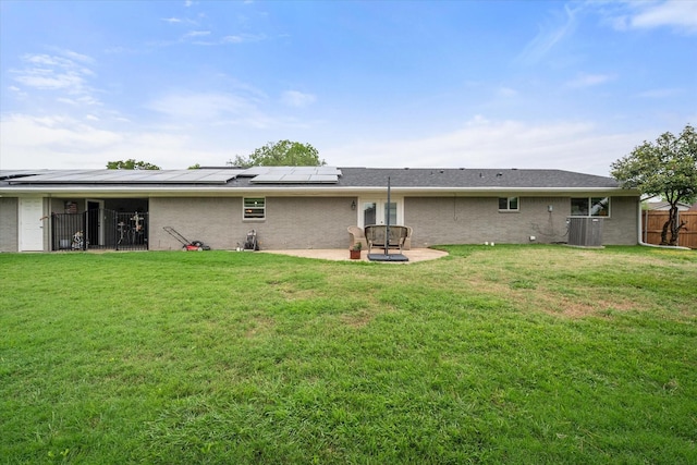 1410 Hummingbird Dr, Hillsboro, TX 76645 - rear view of house featuring fence, roof mounted solar panels, a yard, and a patio area