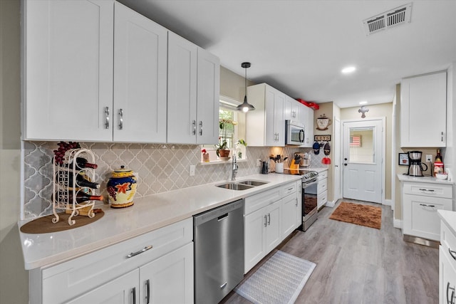1410 Hummingbird Dr, Hillsboro, TX 76645 - kitchen featuring stainless steel appliances, light wood-style floors, white cabinets, a sink, and visible vents