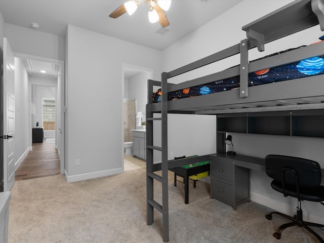 bedroom with ensuite bathroom, baseboards, and light carpet