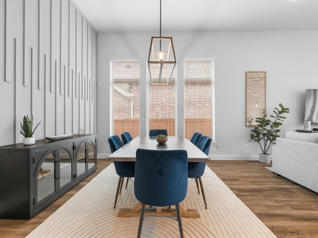 dining space with dark wood finished floors, baseboards, and a healthy amount of sunlight