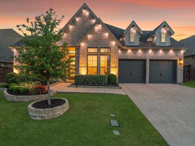 traditional-style house with concrete driveway, a yard, and brick siding