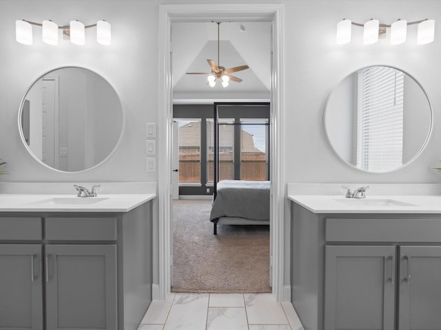 bathroom featuring two vanities, ceiling fan, marble finish floor, and a sink