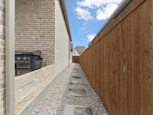 view of side of property with fence and brick siding