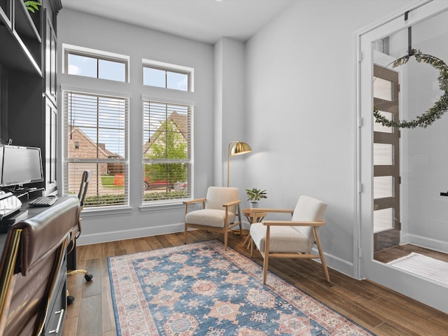 sitting room with baseboards and wood finished floors