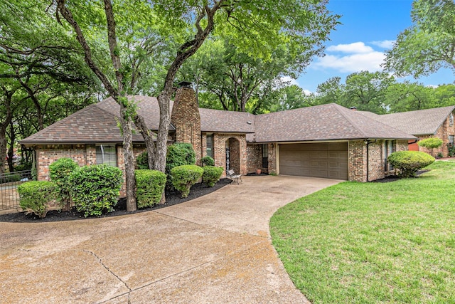 ranch-style home with roof with shingles, an attached garage, brick siding, a chimney, and concrete driveway