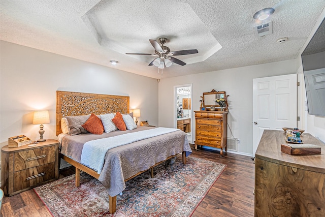 bedroom featuring dark wood-style flooring, a textured ceiling, visible vents, and a ceiling fan