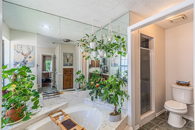 full bath with tile patterned flooring, toilet, a textured ceiling, a garden tub, and a stall shower