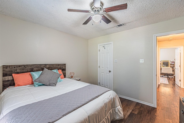 bedroom featuring baseboards, a textured ceiling, visible vents, and wood finished floors