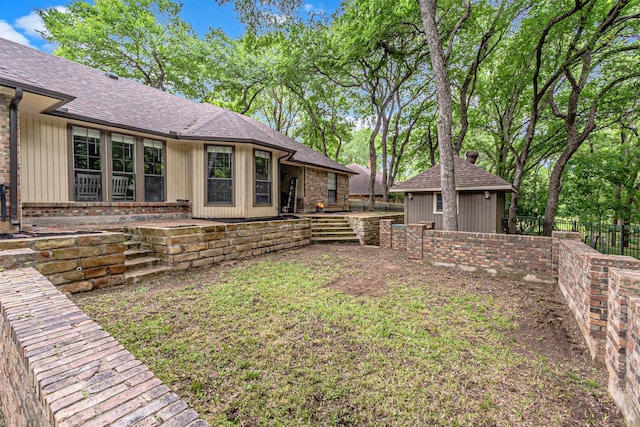 view of yard with fence, an outbuilding, and a shed