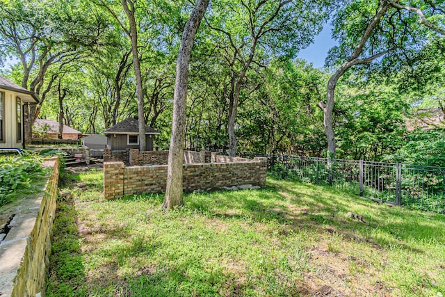 view of yard with an outdoor structure, a storage shed, and a fenced backyard