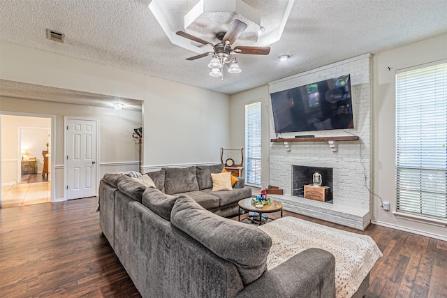 living area featuring wood finished floors, a textured ceiling, and visible vents